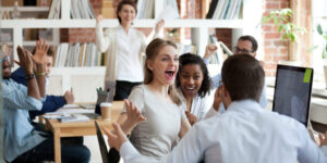Excited diverse business team employees screaming celebrating good news success